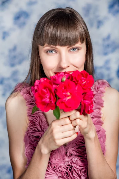 Vacker flicka med röda blommor — Stockfoto