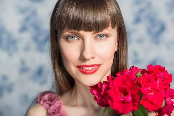 Beautiful girl with red flowers — Stock Photo, Image