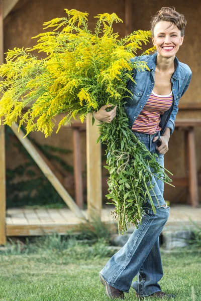 Glückliche junge Frau mit Blumen — Stockfoto