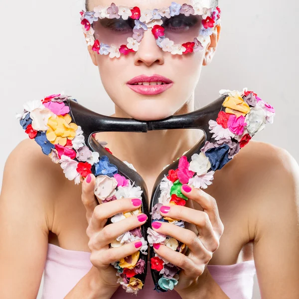 Mulher de moda usando óculos de sol segurando sapatos — Fotografia de Stock