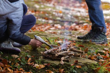 Çocuk kamp ateşi yakıyor. Kamp macerası.
