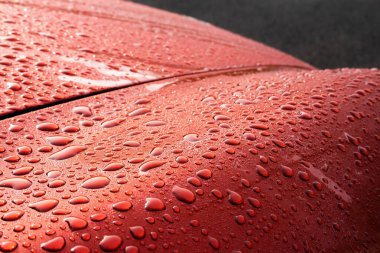 Yağmurdan sonra ıslak kırmızı araba - yansıma ve doku. Su konsepti boncukları, şehir şiiri