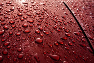 Yağmurdan sonra ıslak kırmızı araba - yansıma ve doku. Su konsepti boncukları, şehir şiiri