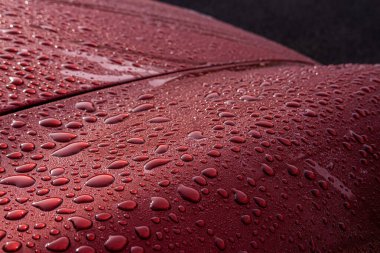 Yağmurdan sonra ıslak kırmızı araba - yansıma ve doku. Su konsepti boncukları, şehir şiiri