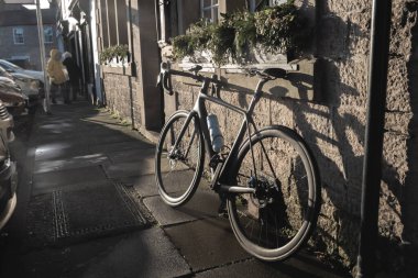 Sunlit caddesinde bahar bisikleti, şehir manzarası. Bisiklet bir kahve dükkanının yakınına park edilmiş. Kahve molası.