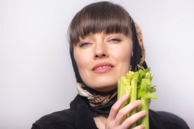 Kereviz tutan güzel kadın, sağlıklı beslenme konsepti.