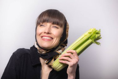 Kereviz tutan güzel kadın, sağlıklı beslenme konsepti.