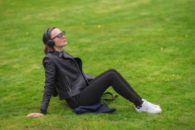Parkta güneşli bir bahar gününün tadını çıkaran bir kadın. Dışarıda mutlu bir kadın var. Taze bir başlangıç, bahar neşesi