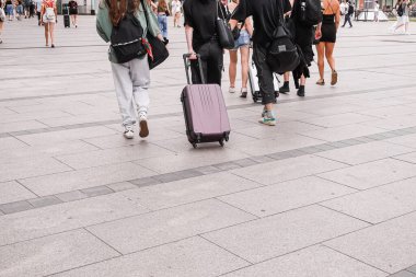 Krakow, Polonya - 27 Haziran 2024: Krakow 'da insanlar bavullarıyla sokakta yürüyorlar