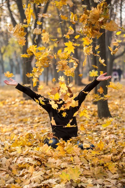 Szczęśliwa kobieta jesień rzucać żółte liście — Zdjęcie stockowe