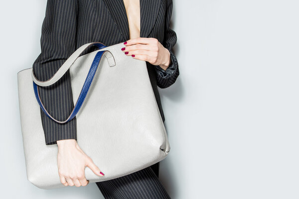 Мода модель с мешком на сером фоне
