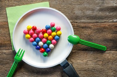 Sevgililer günü kümesiyle kalp ve kırsal ahşap masa üzerinde tava