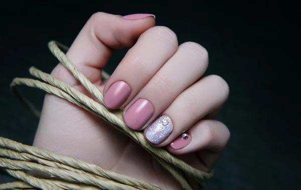 Vacker kvinnlig hand med beige nageldesign. — Stockfoto