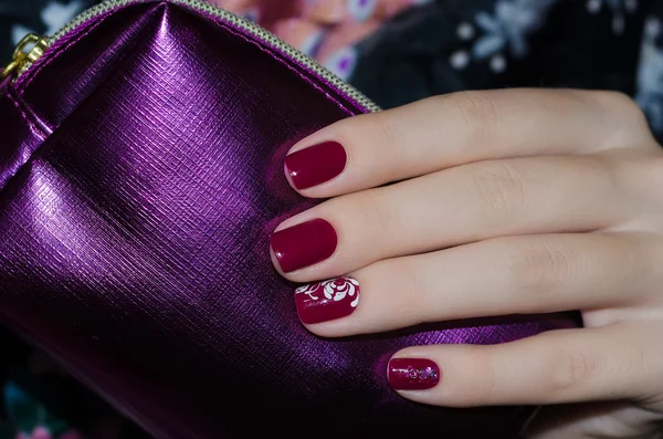 Kvinna hand med mörkt röda nail design — Stockfoto