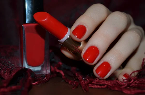 Röda naglar och rött läppstift — Stockfoto