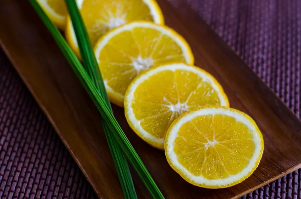 Naranja en rodajas en un plato de madera — Foto de Stock