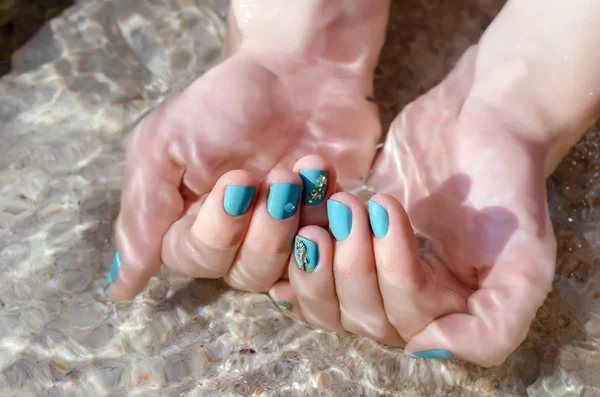 Ręka kobiety z turkusem paznokci projekt w Kryształowej wody morskiej. — Zdjęcie stockowe