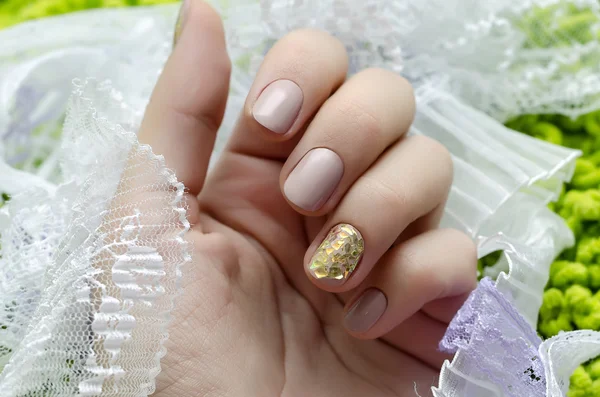 Hermosa mano femenina con diseño de uñas beige. — Foto de Stock