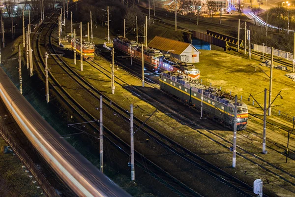 Ночной город с высокой точки с поездами — стоковое фото