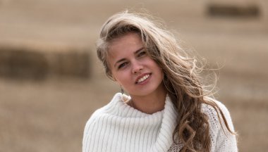 Tarla sonbaharda sarı ve kahverengi renkler güzel genç kadın kapatmak gülümseyerek