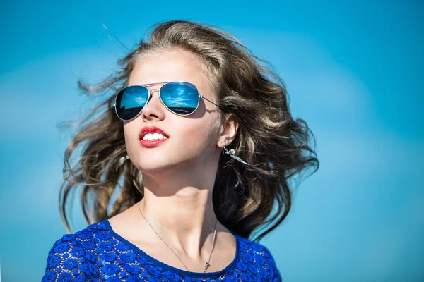 Hermosa mujer joven al aire libre sobre el cielo azul en gafas de sol Imagen de archivo