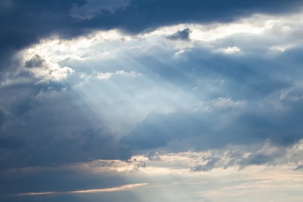 Rayos crepusculares al atardecer vertiendo aunque nubes dispersas —  Fotos de Stock