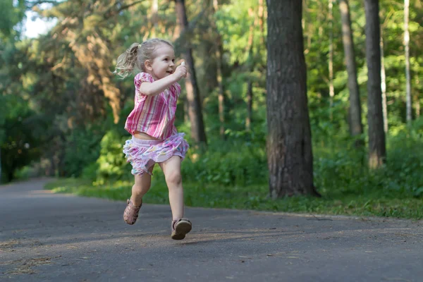 Exited trzech lat dziewczyna runner na asfalt parku chodnik trzymając kawałek kredy posadzkowe — Zdjęcie stockowe