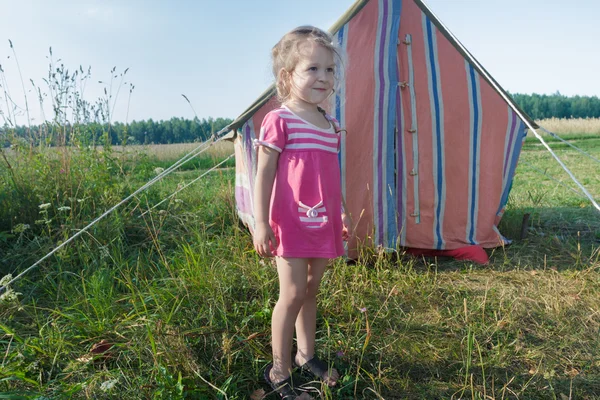 Loira campista menina desfrutando de lazer ao ar livre perto de tenda de lona vintage listrada — Fotografia de Stock