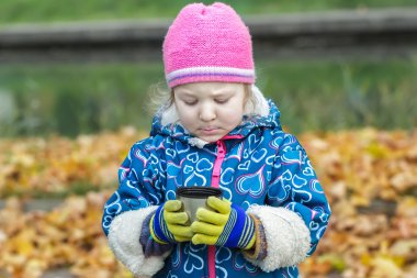 Holding ve çelik termos flask Kupası'nda arıyorsunuz küçük kız sonbahar piknik portresi
