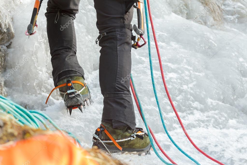 Close up of Ice climbing mountaineer legs with professional sport boots and equipment