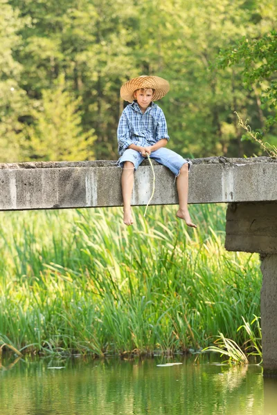 Adolescente ragazzo pesca con asta sul ponte — Foto Stock