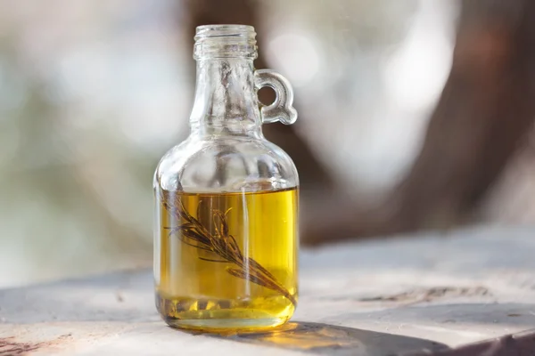 Botella con aceite de oliva y ramita de romero verde — Foto de Stock