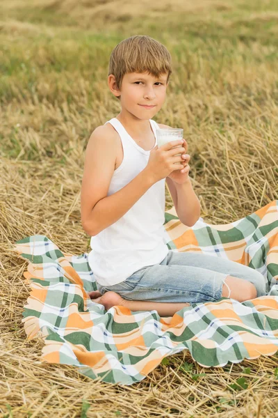 Ragazzo adolescente che beve latte crudo fresco dal vetro — Foto Stock