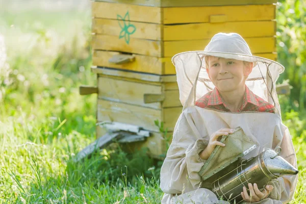 Apicultor adolescente con colmenas de madera pintadas — Foto de Stock