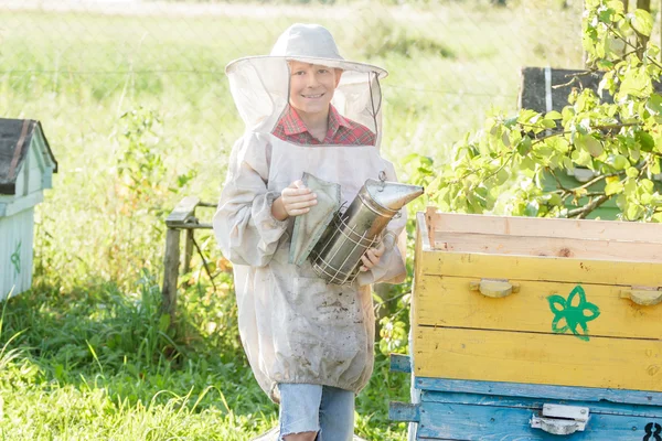 Teenage biodlaren kontrollera bikupor på bee gård — Stockfoto