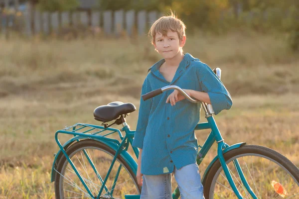 Teenager mit blauem Fahrrad auf Acker — Stockfoto