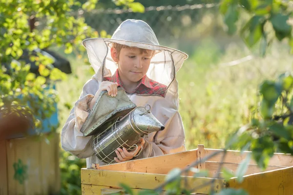 Adolescente apicultor fumar colmena en el patio de la abeja —  Fotos de Stock