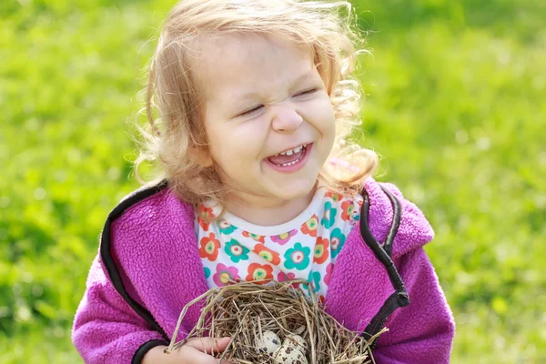Девочка смеется во время хранения гнезда с яйцами — стоковое фото