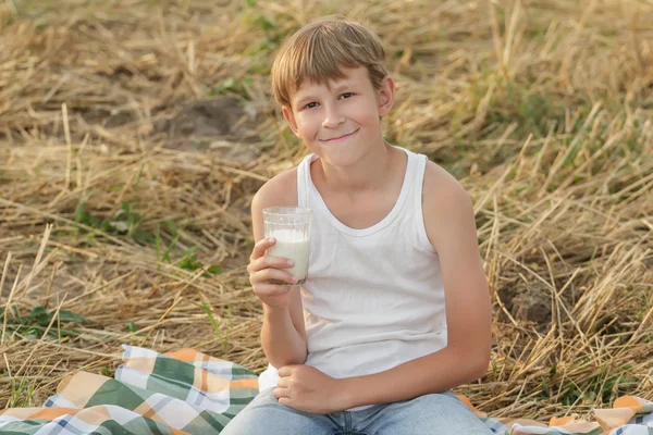 Menino adolescente na fazenda detém copo de leite cru — Fotografia de Stock