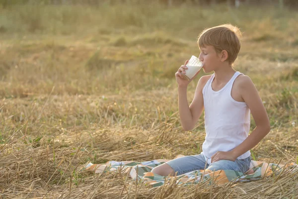 Teenage farmer boy with closed eyes drinks milk — Stock Photo, Image