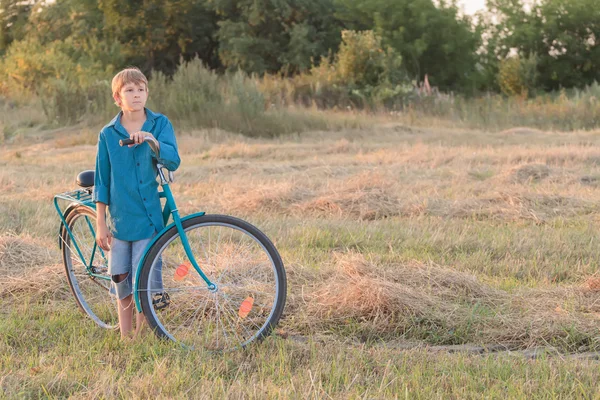 Ragazzo adolescente con bici blu in campo agricolo — Foto Stock