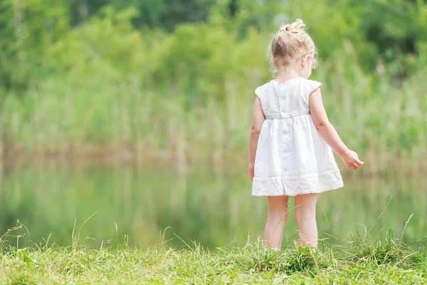 Niña en vestido de verano ligero cerca del estanque del bosque — Foto de Stock