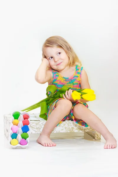 Niña sostiene tulipanes con huevos de Pascua — Foto de Stock