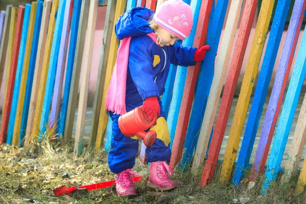 Dos años niña regando tierra en el jardín —  Fotos de Stock