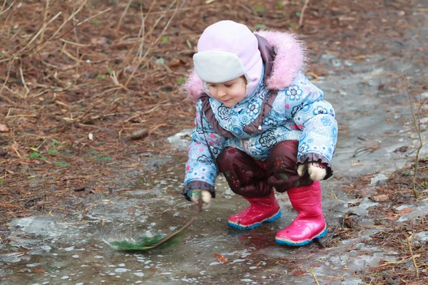 Маленькая девочка исследует ледяную лужу — стоковое фото