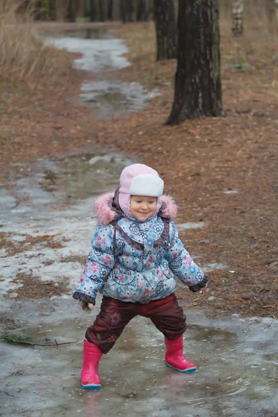 Twee jaar oud meisje spelen in ijzige Plas — Stockfoto