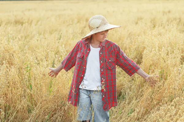 Portrait of teenage farm boy in checkered shirt and wide-brimmed straw hat Stock Photo