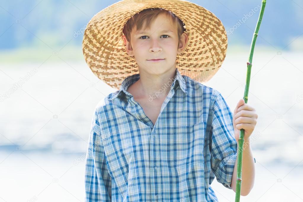 Portrait of teenager with handmade green twig fishing rod