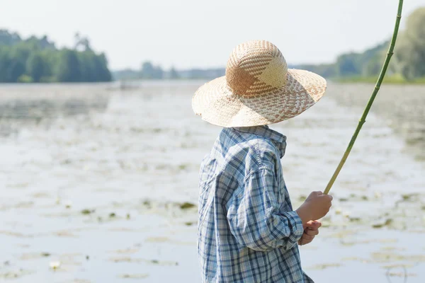 Chico pescador está masticando caña de pescar hecha a mano —  Fotos de Stock