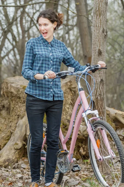 Sorpresa ragazza bruna che cammina e tiene vintage bicicletta rosa — Foto Stock